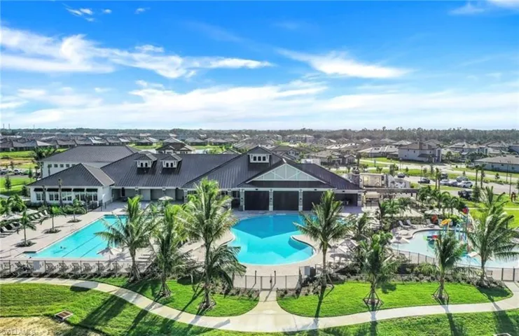 Community pool with a patio, a lawn, and a residential view