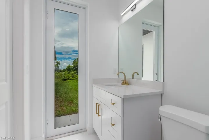 Bathroom with a wealth of natural light, toilet, and vanity with extensive cabinet space