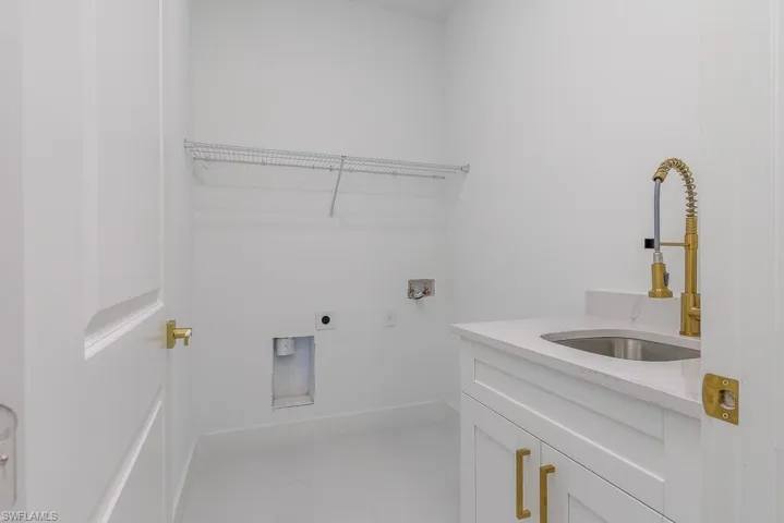 Washroom featuring cabinets, tile flooring, hookup for a washing machine, electric dryer hookup, and sink