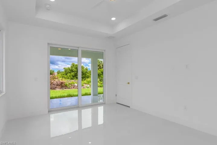Spare room with a tray ceiling and tile flooring