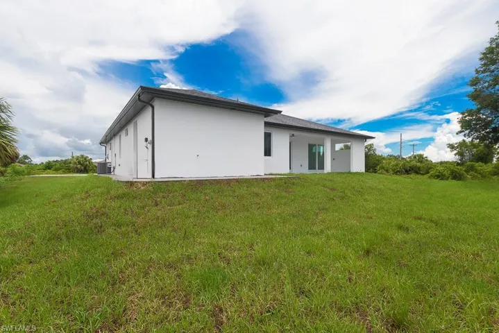 Back of house with a lawn