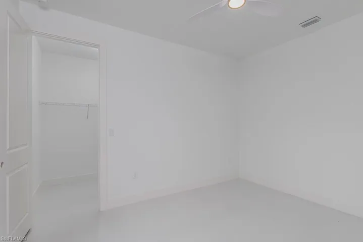 Empty room featuring ceiling fan and concrete flooring