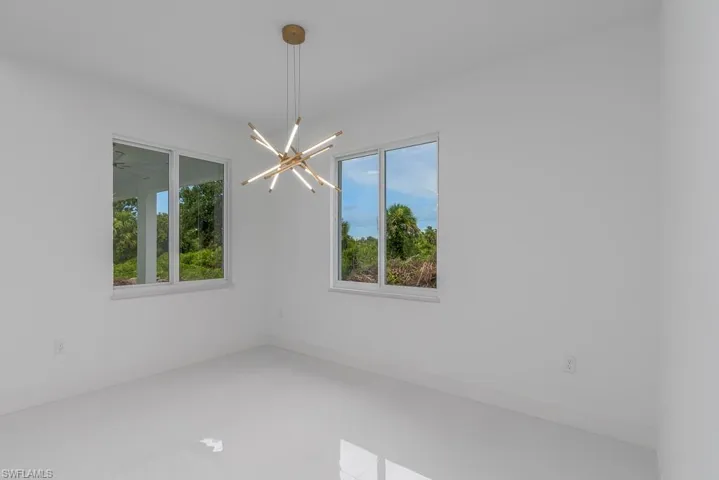 Unfurnished room featuring a chandelier
