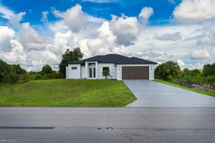 View of front of house with a front yard and a garage