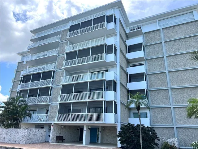 Multi-story condominium building featuring a textured exterior facade and multiple private balconies