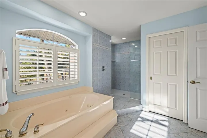 Bathroom featuring tile patterned flooring and separate shower and tub