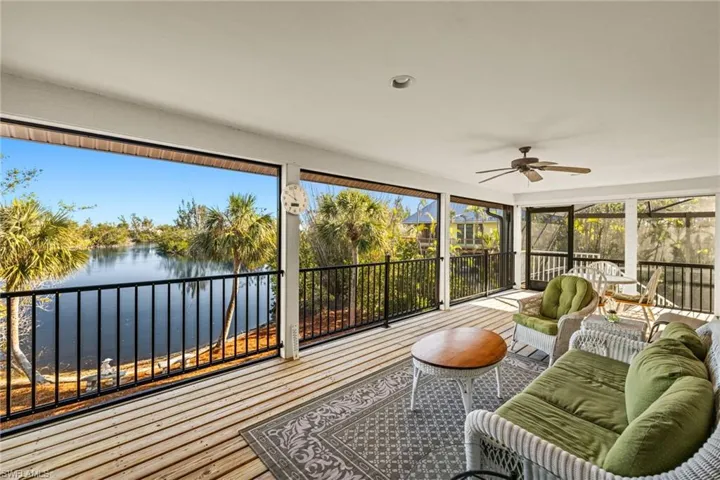 Sunroom / solarium featuring ceiling fan and a water view