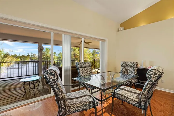 Dining room with vaulted ceiling, a water view, and wood-type flooring