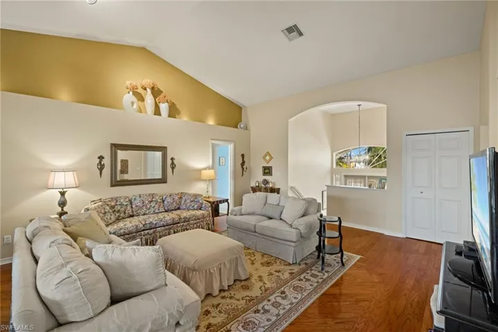 Living room featuring high vaulted ceiling and dark hardwood / wood-style flooring