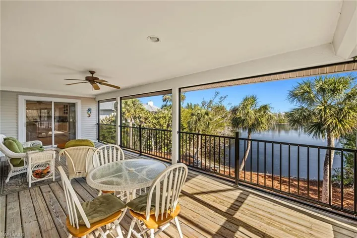 Sunroom / solarium with a water view and ceiling fan
