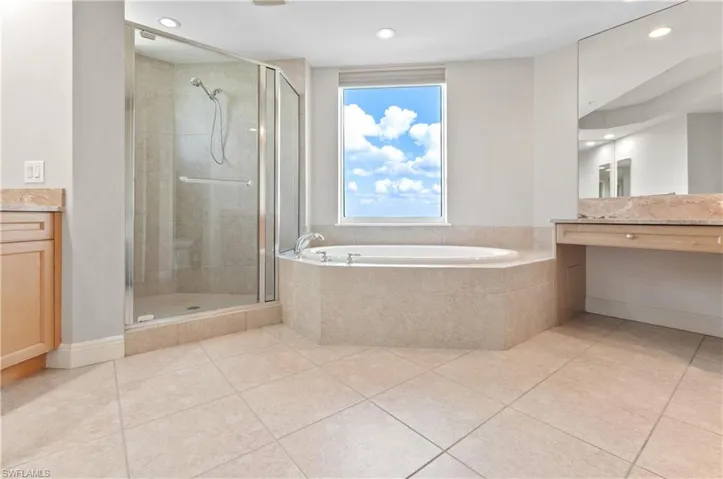 Full bath with vanity, a bath, a stall shower, light tile patterned floors, and recessed lighting