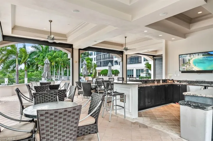 View of patio with ceiling fan and an outdoor bar and dining area