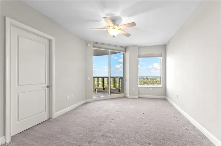 Empty room featuring a ceiling fan and carpet floors