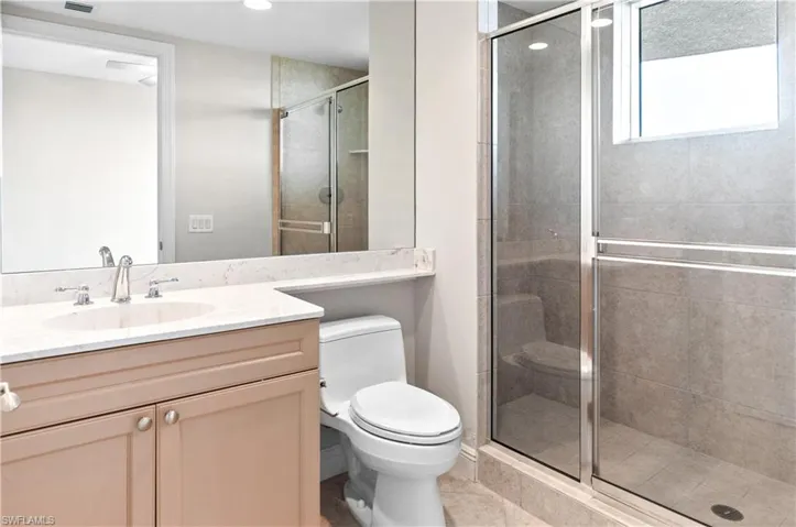 Full bathroom featuring vanity, a stall shower, and light tile patterned floors