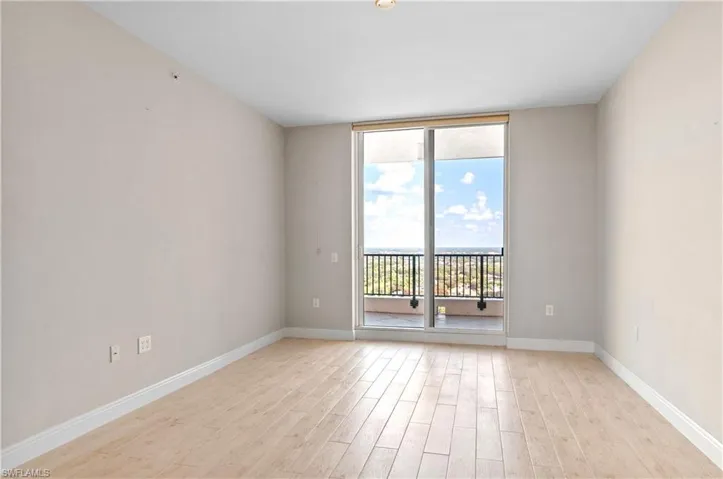 Unfurnished room featuring floor to ceiling windows and light wood-type flooring