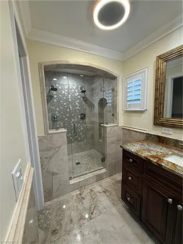 Expansive master bathroom with walk-in shower with dual showerheads, glass enclosure, and decorative tile accents
