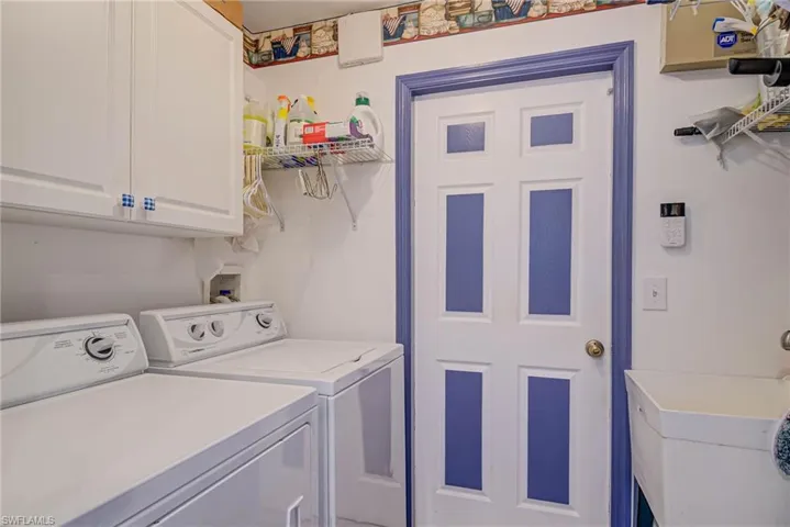 Laundry area featuring washer and dryer, cabinet space, and a sink