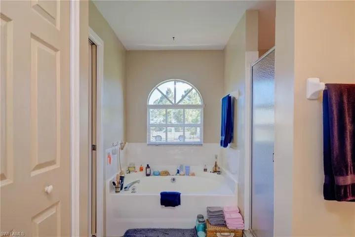Full bath featuring a garden tub and a shower stall