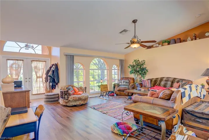 Living area with plenty of natural light, visible vents, wood finished floors, and french doors