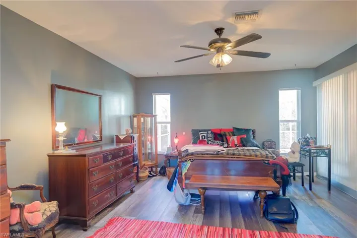 Bedroom featuring visible vents, wood finished floors, and ceiling fan