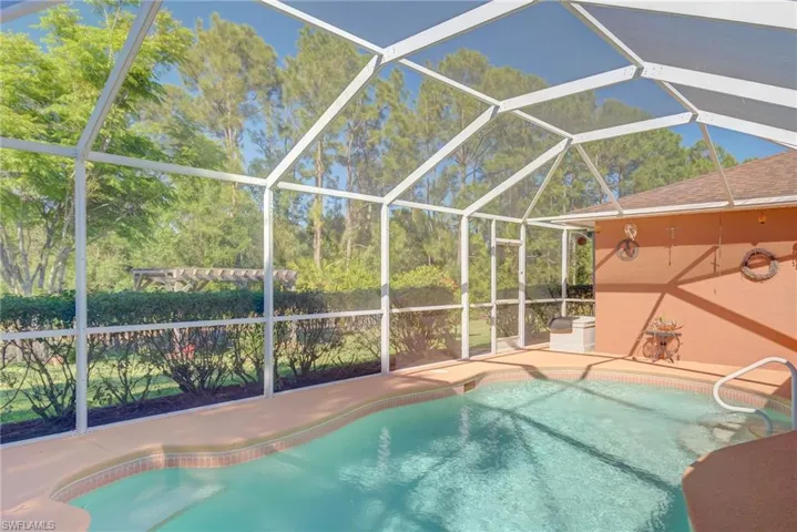 Pool featuring glass enclosure and a patio area