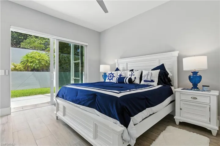 Bedroom with access to outside, wood finished floors, and a ceiling fan