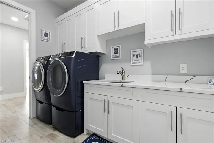 Washroom with washer and dryer, cabinet space, light wood-style floors, and recessed lighting