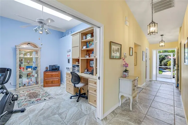 Home office featuring lofted ceiling, baseboards, visible vents, and a ceiling fan