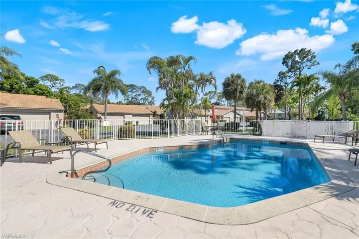 Community pool featuring a patio and fence