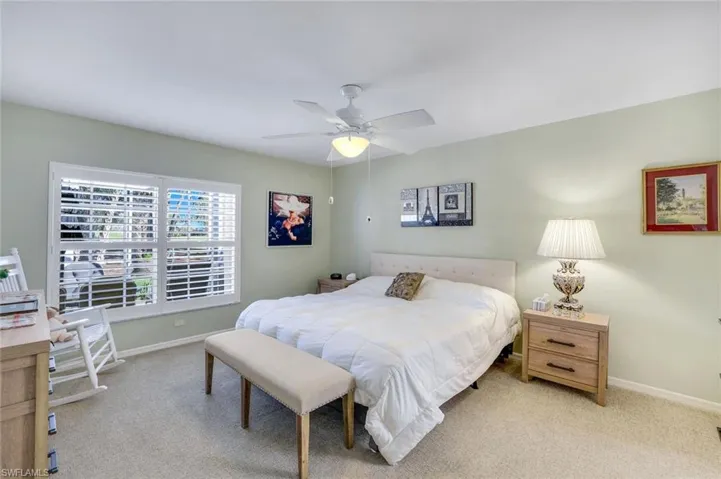 Bedroom featuring a ceiling fan, light colored carpet, and baseboards