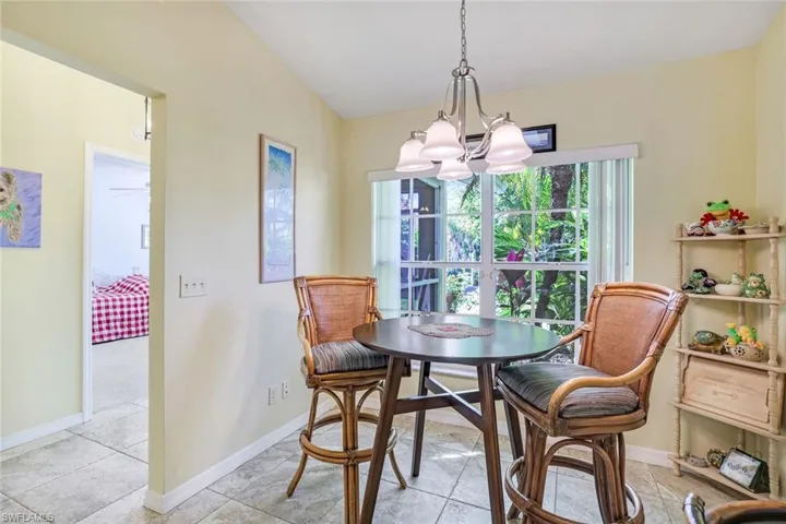 Dining area with baseboards, vaulted ceiling, and a notable chandelier