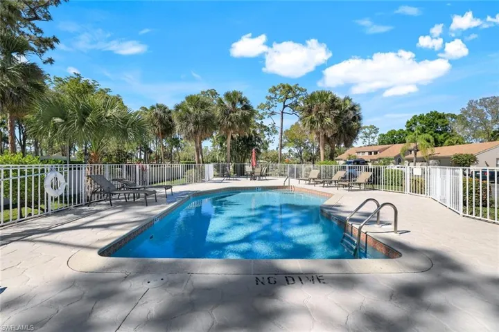 Community pool featuring a patio and fence