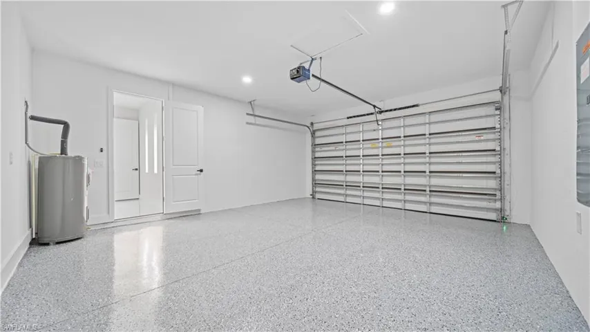 Garage featuring electric water heater and recessed lighting