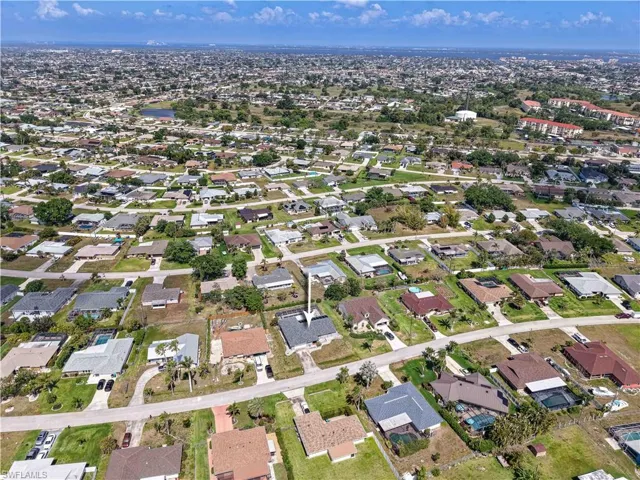 Aerial view of property and surrounding area featuring nearby suburban neighborhood