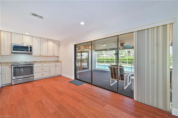 Kitchen featuring stainless steel appliances, light stone countertops, floorinrecessed lighting, Tile floors, and cream cabinetry