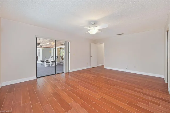 Unfurnished room with a textured ceiling, a ceiling fan, and light wood-type flooring