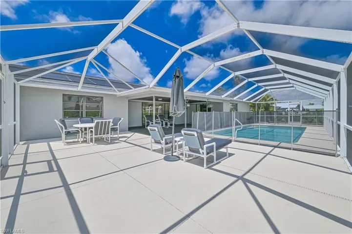View of swimming pool featuring a sunroom, a patio, and screened enclosure