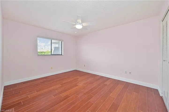 Unfurnished room with a textured ceiling, wood-type Ceramic Tile flooring, and ceiling fan