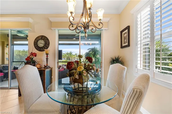 Dining room with crown molding, a chandelier, and tile patterned flooring