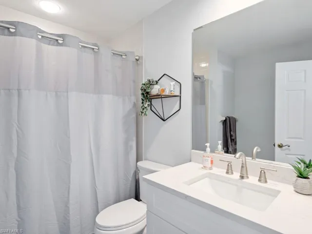 Bathroom featuring toilet and vanity with extensive cabinet space