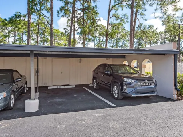 View of parking / parking lot with a carport