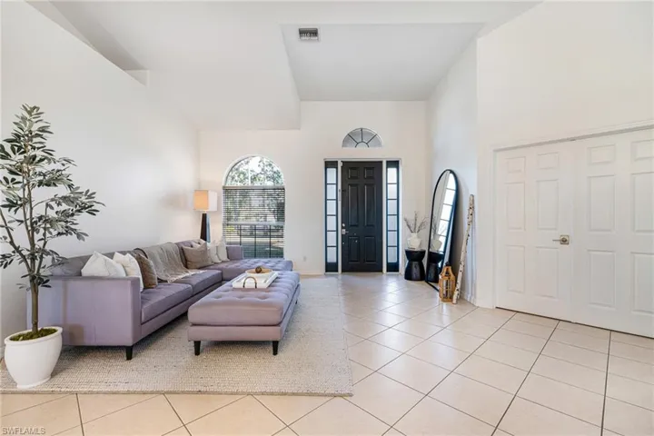 Living area with a towering ceiling and light tile patterned flooring