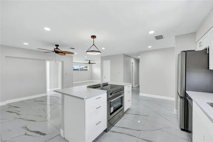 Kitchen with appliances with stainless steel finishes, marble finish floor, a ceiling fan, and recessed lighting