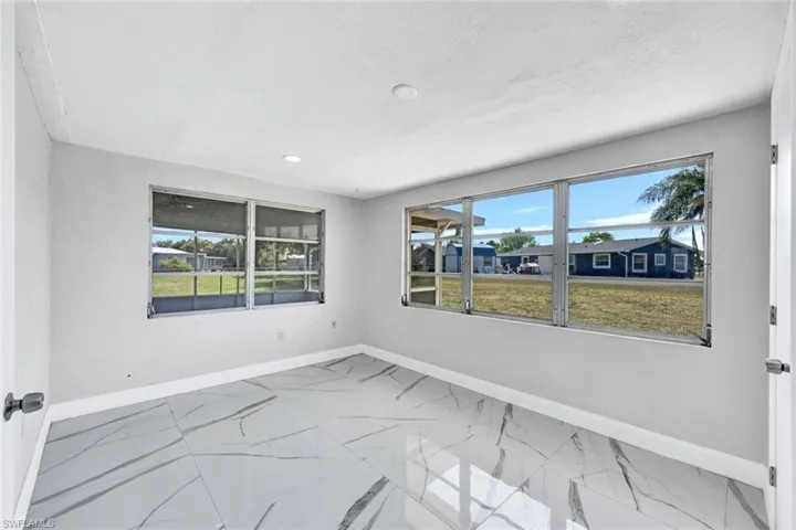 Unfurnished room featuring marble finish floor, baseboards, and recessed lighting