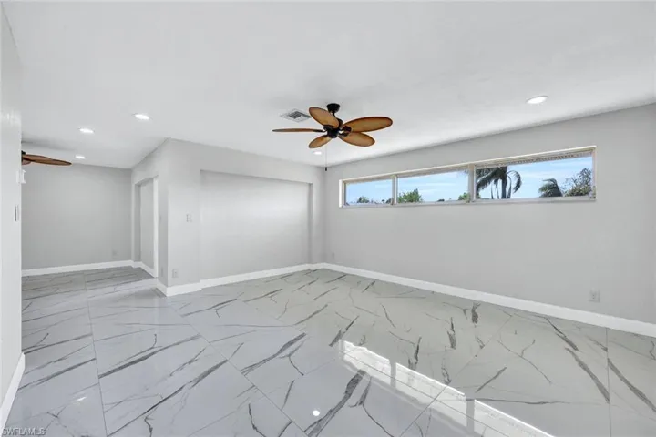 Spare room featuring ceiling fan, recessed lighting, marble finish floor, and baseboards