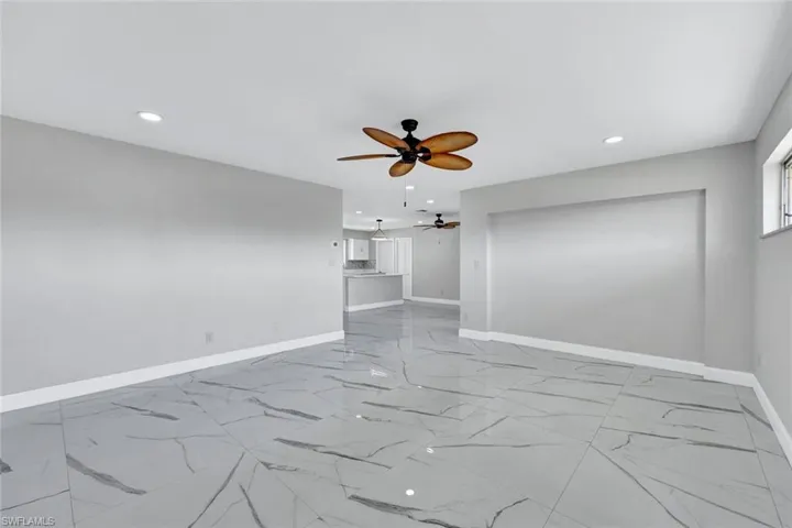 Spare room with marble finish floor, ceiling fan, baseboards, and recessed lighting