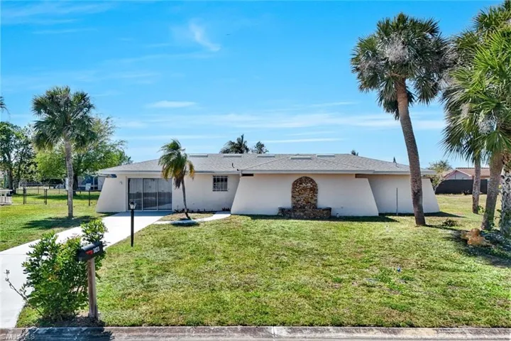 Ranch-style house with stucco siding and a front lawn