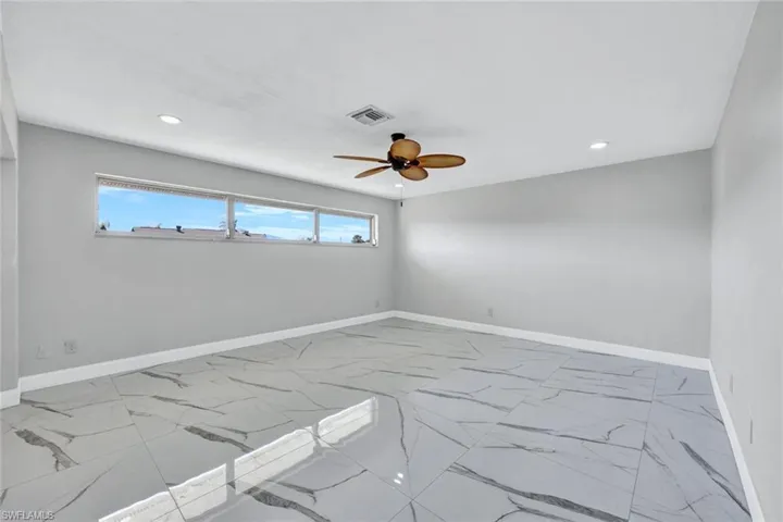 Empty room featuring ceiling fan, baseboards, visible vents, and recessed lighting