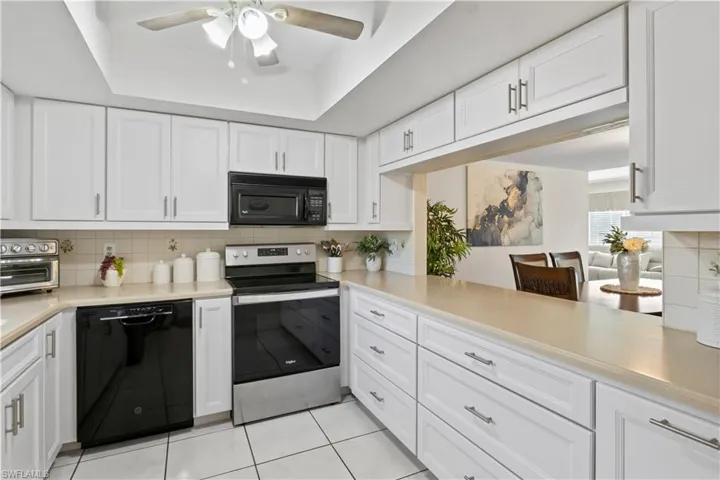 Nicely updated kitchen with white cabinetry and corian countertops.
