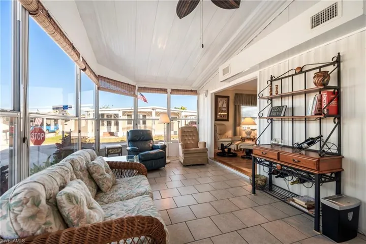 Sunroom with tile patterned floors and vaulted ceiling